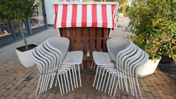 Zusammengestellte Stühle und ein geschlossener Strandkorb stehen an der Promenade von Timmendorfer Strand.
