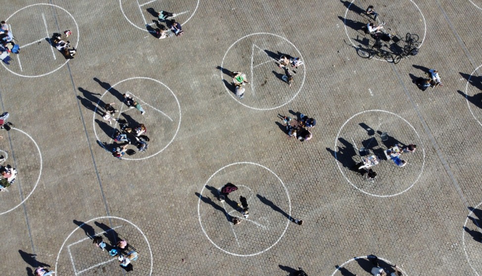People relax inside social distancing circles in Ghent