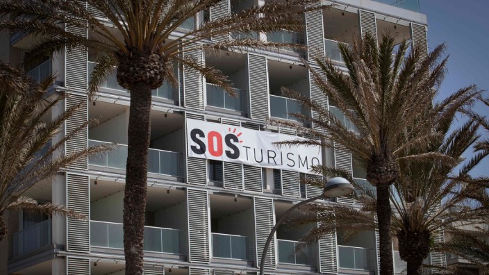 Tourismus: Ein Banner mit der Aufschrift "SOS Tourismus" hängt an der Fassade eines geschlossenen Hotels am Strand von Palma de Mallorca.