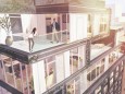 Frau und Mann treffen sich auf der Dachterrasse eines Luxus Penthouses auf einem modernen Wohnblock