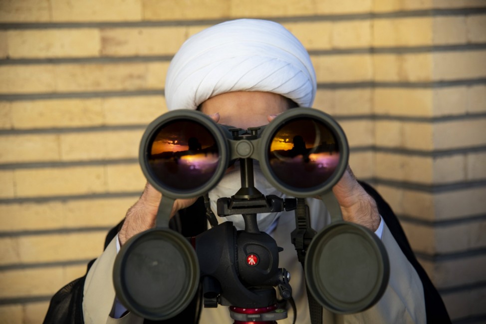 Iran: Observation of the new moon of Ramadan An Iranian cleric scans the sky with a pair of binoculars as he tries to fi