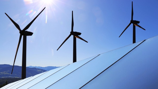 Symbolbild Energiewende: Solardach mit Windkraftanlagen im Hintergrund (Composing) *** Symbolic image Energy revolution