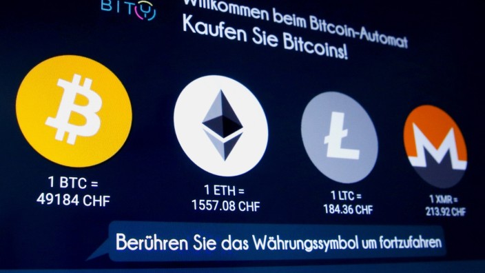 FILE PHOTO: The exchange rates and logos of Bitcoin, Ether, Litecoin and Monero are seen on the display of a cryptocurrency ATM in Zurich