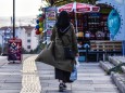 April 29, 2021, Ankara, Turkey: A woman holding shopping bags walks past a a small market before the start of a full lo