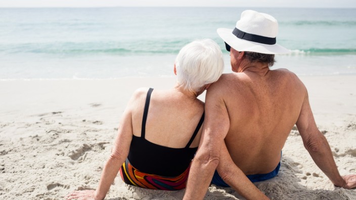 Rear view of senior couple sitting on beach