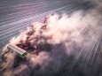 Ackerbau - Trockenheit, Traktor verschwindet bei der Aussaat von Winterraps in einer Staubwolke, Luftaufnahme. Luftaufn