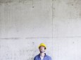 Man with hard hat on construction site at concrete wall looking up model released Symbolfoto propert