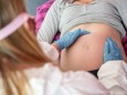 Eine Hebamme untersucht eine schwangere Frau