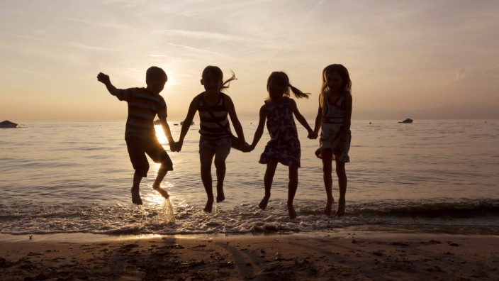 Italy Lake Garda children jumping on beach at sunset model released Symbolfoto PUBLICATIONxINxGERx