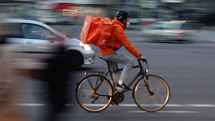 03.03.2021, Berlin, GER - Mitarbeiter von Lieferando faehrt eine Bestellung mit dem Fahrrad aus. (Alltag, ausliefern, au