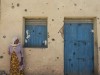 In Tigray leidet vor allem die Zivilbevölkerung unter dem Krieg - wie diese Frau, die an einem von Kugeln getroffenen Haus steht.