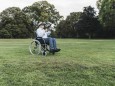 Senior man sitting in wheelchairin a park using Virtual Reality Glasses model released Symbolfoto PUBLICATIONxINxGERxSUI