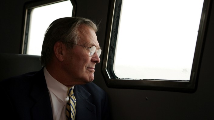 FILE PHOTO: Secretary of Defense Donald Rumsfeld looks through a window of an armoured vehicle while touring Abu Ghraib prison outside Baghdad