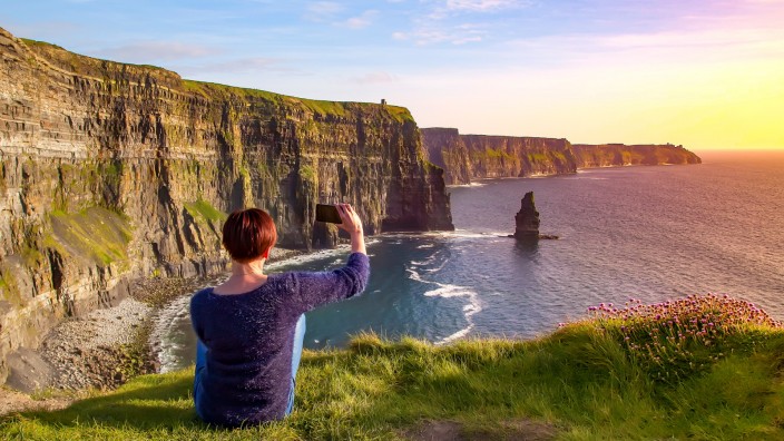 Woman taking picture of Of Cliffs Of Moher, Liscannor, Ireland