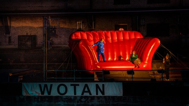 Open-Air-Spektakel: Das Schubboot heißt Wotan und trägt ein hüpfburggroßes, rotes Sofa, auf dem sich die Götter tummeln.