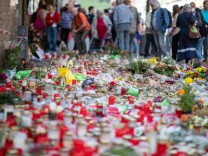 Attentat in Würzburg: Grablichter und Blumen liegen vor einem Kaufhaus in der Innenstadt