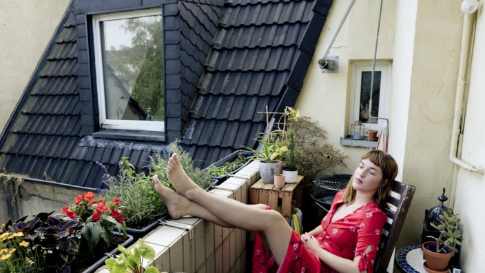 Wohnen und Mieten: Eine Frau entspannt auf dem Balkon