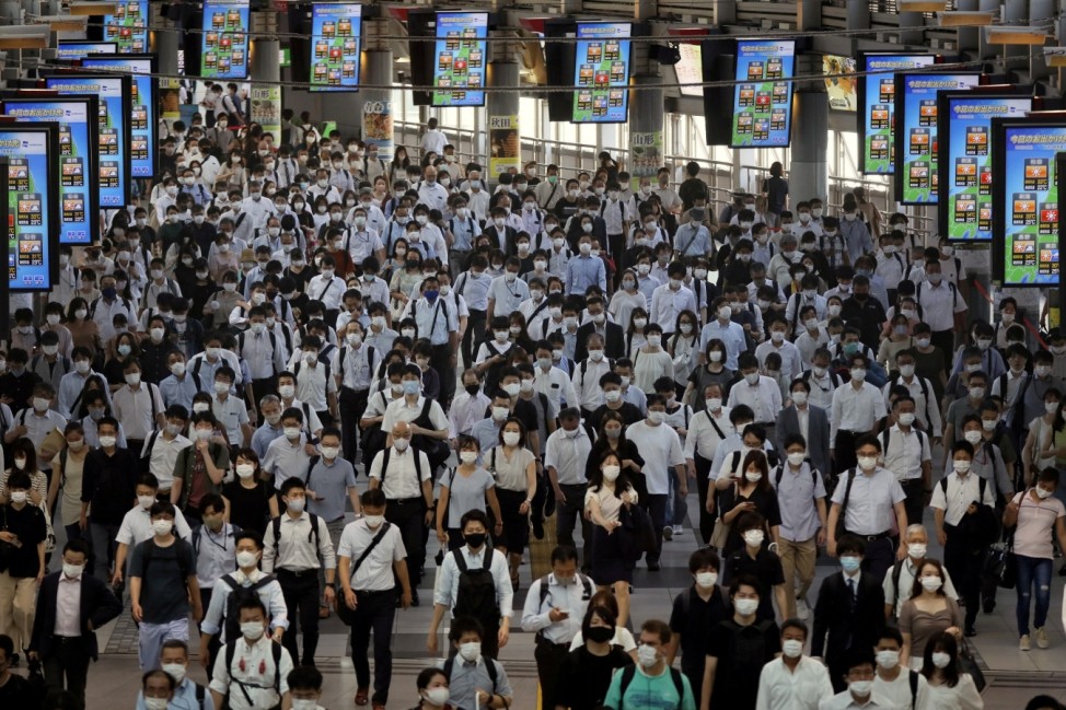 Commuters wearing face masks arrive at Shinagawa Station