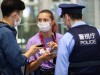 Belarusian athlete Krystsina Tsimanouskaya talks with a police officer at Haneda international airport in Tokyo, Japan