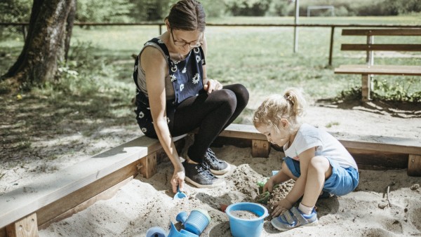Mother playing with little daughter in sandbox on a playground model released Symbolfoto PUBLICATION