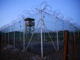 FILE PHOTO: Chain link fence and concertina wire surrounds a deserted guard tower within Joint Task Force Guantanamo's Camp Delta