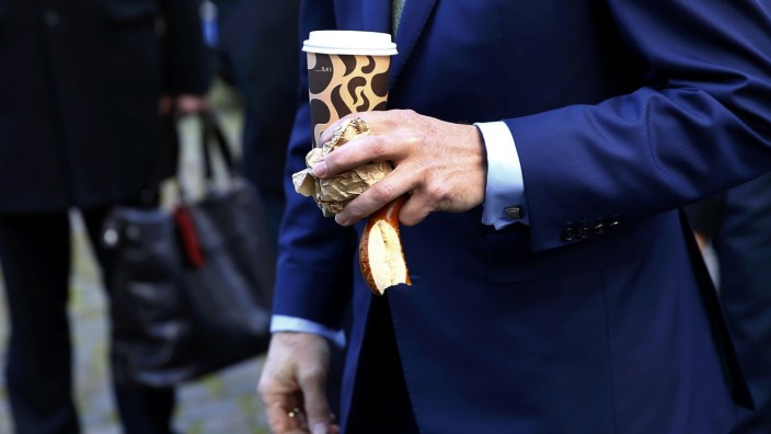 Kengeter, CEO of Deutsche Boerse holds a cup of coffee and a breztel as he arrives for the presentation of a FinTec start-up facilities provided by Deutsche Boerse in Frankfurt