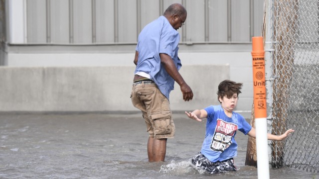 Hurrikan "Ida" in den USA: Ein Junge und sein Stiefvater versuchen in Saint Rose, eine Straße zu überqueren.