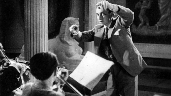 Biografie: Paul Abraham dirigiert - wie immer mit weißen Handschuhen, die den Dirigentenstab ersetzen - während der Filmaufnahmen seiner eigenen Operette "Viktoria und ihr Husar" (Regie: Richard Oswald, Deutschland 1931).