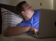 Worried Teenage Boy Using Laptop In Bed At Night model released Symbolfoto property released PUBLICA