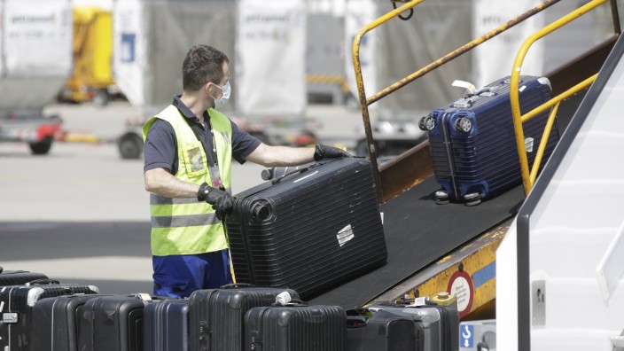 Reise: Am Münchner Flughafen werden Koffer entladen. Vielen Airports mangelt es an Personal.