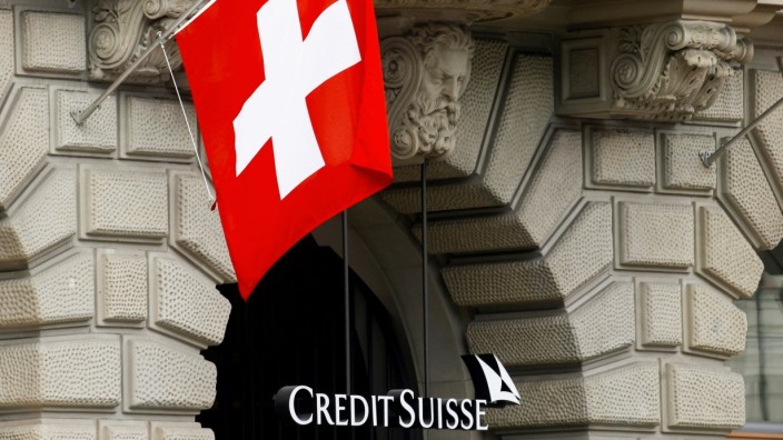 FILE PHOTO: Switzerland's national flag flies above the logo of Swiss bank Credit Suisse in Zurich
