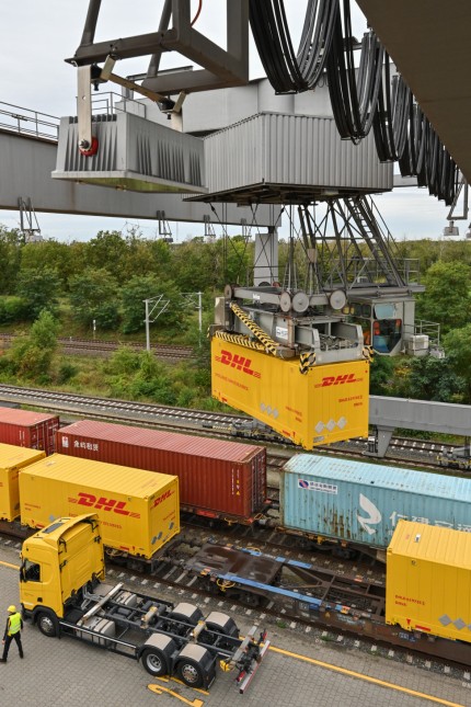 Gütertransport: Ein Container von Deutsche Post DHL wird an einem Verladebahnhof in Großbeeren in Brandenburg vom Lkw auf einen Waggon der Deutschen Bahn gehoben.
