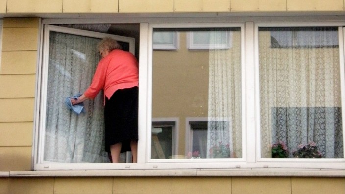 Rentnerin beim Fensterputzen