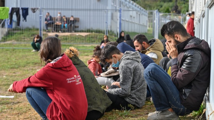 Flüchtlingspolitik: Migranten sitzen in Eisenhüttenstadt vor Containern des Brandenburger Aufnahmezentrums.