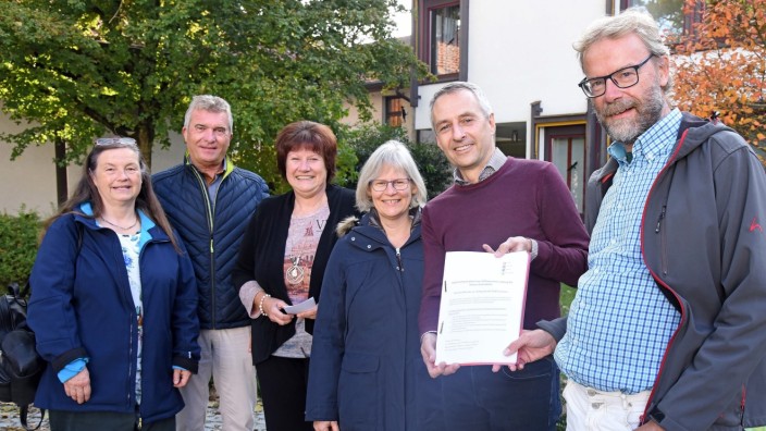 Wohnungsbau in Puchheim: Mitglieder der Bürgerinitiative übergeben die Unterschriftenliste an Bürgermeister Norbert Seidl (Fünfter von links).