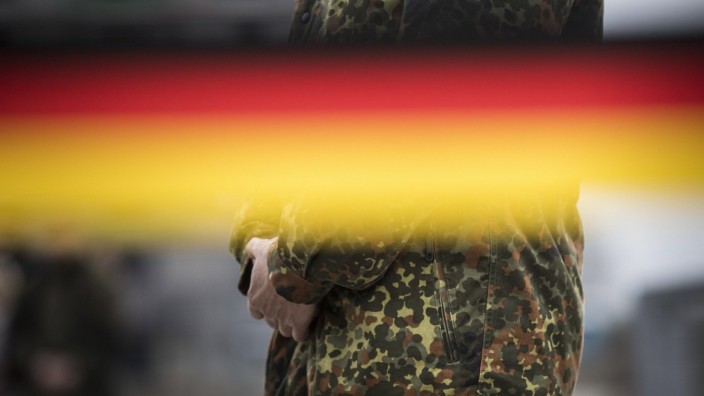 Ein Soldat zeichnet sich hinter einer schwarz-rot-goldenen Banderole ab. Schnoeggersburg, 26.10.2017. Schnoeggersburg D