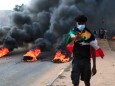Putsch in Sudan: Ein Demonstrant vor brennenden Barrikaden in Khartum