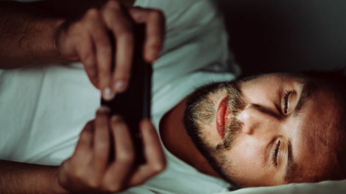 Young man cannot sleep and is watching something on his phone Wlodawa, Lubelskie, Poland PUBLICATIONxINxGERxSUIxAUTxONL