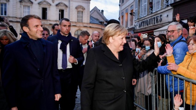 France's President Emmanuel Macron is greeted by members of the public with outgoing German Chancellor Angela Merkel upon their arrival prior to talks, in Beaune