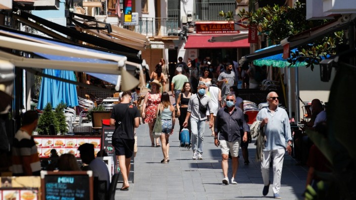 People walk at a pedestrian area in Sitges town