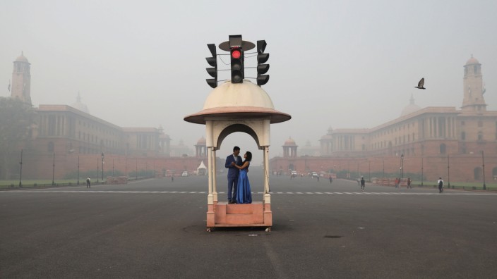 A couple poses during a pre-wedding photo shoot near India's Presidential Palace which is shrouded in smog, in New Delhi