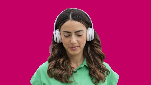 Woman with wireless headphones using smart phone model released Symbolfoto EIF02175