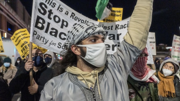 November 19, 2021, New York, New York, United States: A protester chants slogans during a protest march in Brooklyn aga