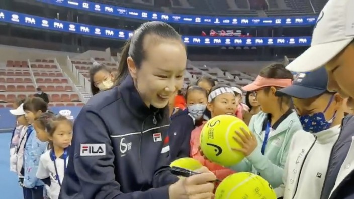 Chinese tennis player Peng Shuai signs large-sized tennis balls at the opening ceremony of Fila Kids Junior Tennis Challenger Final in Beijing