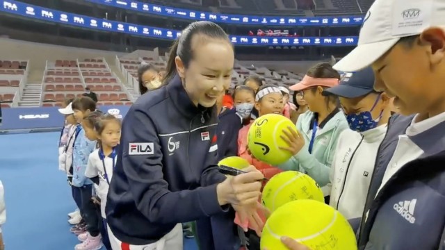 FILE PHOTO: Chinese tennis player Peng Shuai signs large-sized tennis balls at the opening ceremony of Fila Kids Junior Tennis Challenger Final in Beijing