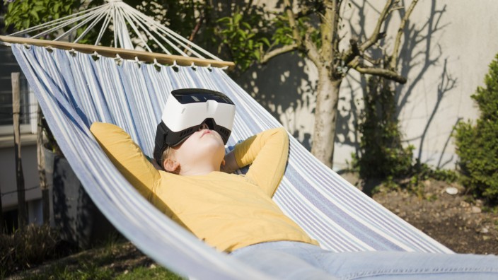 Girl lying in hammock in garden wearing VR glasses model released Symbolfoto property released PUBLI