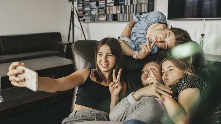 Friends gesturing while taking selfie on sofa at home model released Symbolfoto property released MFF06154