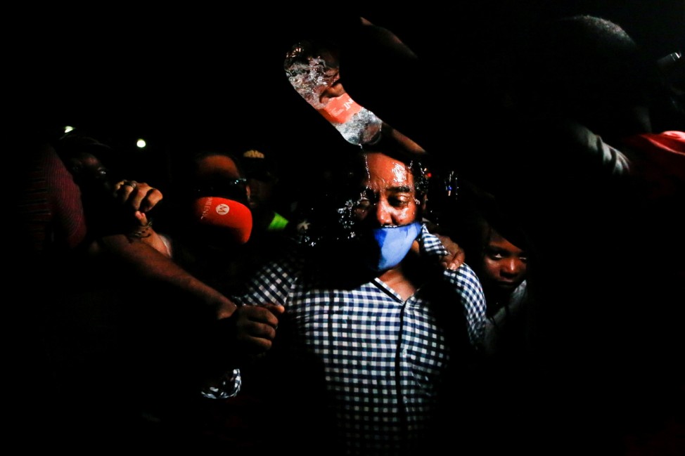 Haitian ambassador in Mexico Hugues Monplaisir Fequiere is poured with water by Haitians who did not get to board buses after accepting an offer from the Mexican government to obtain humanitarian visas, in Tapachula