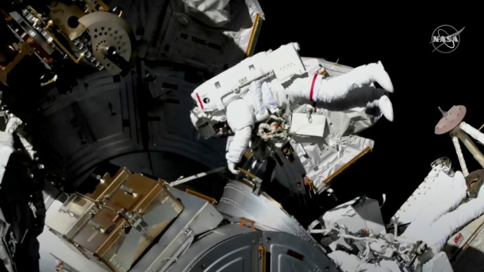 Astronauts conduct a spacewalk to replace a faulty antenna on the International Space Station