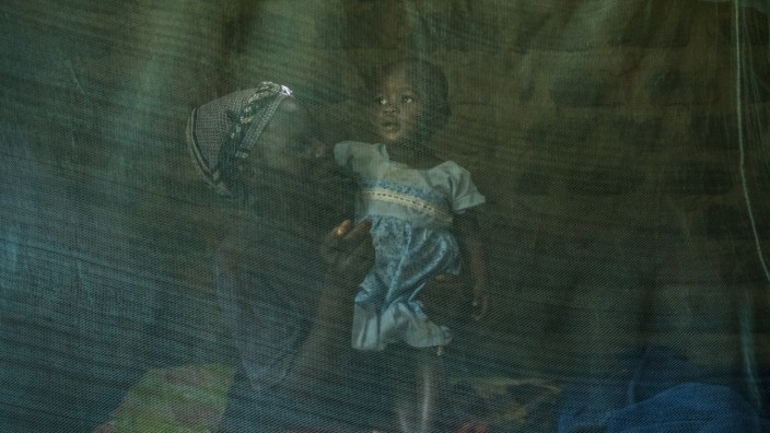 Infektionskrankheiten: Die kleine Margaret Ayuma aus dem Westen Kenias ist zusammen mit ihrer Mutter hinter einem Bettnetz zu sehen. Sie gehört zu den ersten Kindern, die den Malaria-Impfstoff bekommen haben.